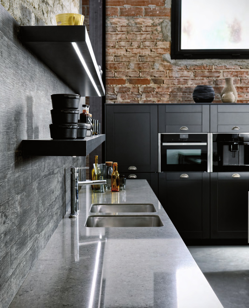Small modern single-wall open plan kitchen in London with a single-bowl sink, shaker cabinets, grey cabinets, quartz worktops, grey splashback, concrete flooring, an island and grey floors.