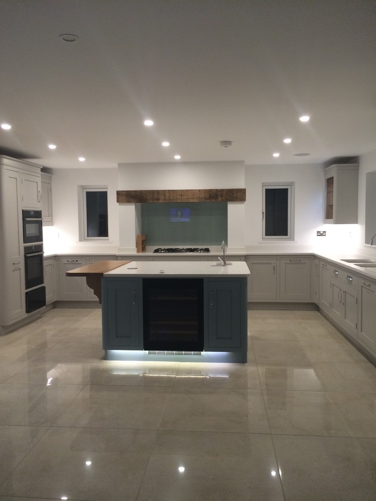 Example of a large trendy porcelain tile open concept kitchen design in Other with an undermount sink, shaker cabinets, gray cabinets, quartzite countertops, gray backsplash, glass sheet backsplash and paneled appliances
