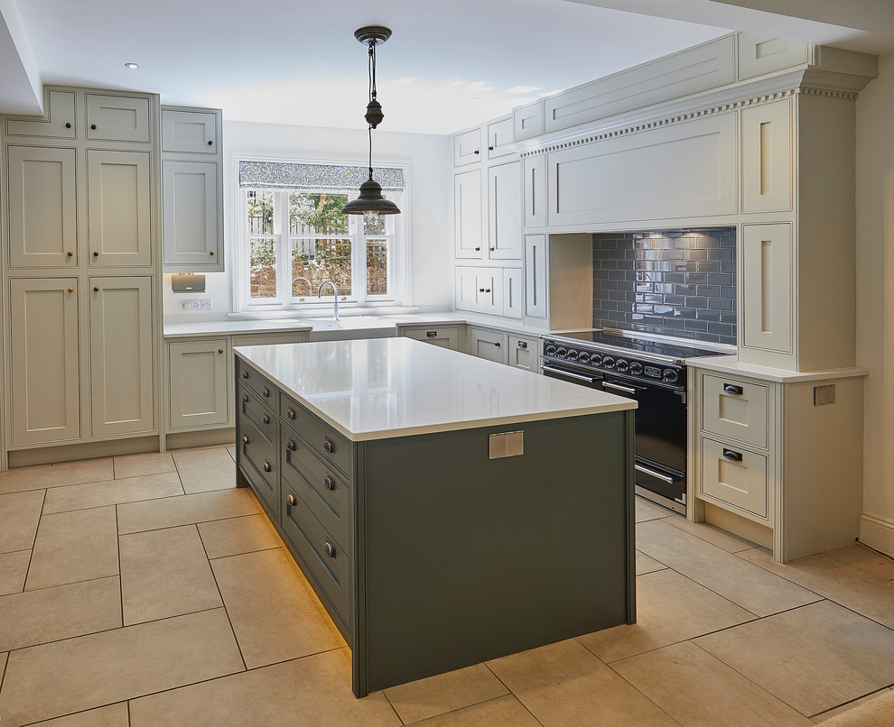Large ornate l-shaped porcelain tile and beige floor eat-in kitchen photo in Surrey with a farmhouse sink, shaker cabinets, gray cabinets, solid surface countertops, gray backsplash, porcelain backsplash, black appliances, an island and white countertops