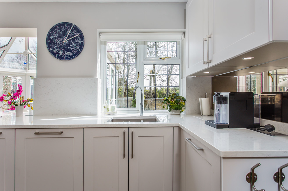 Moderne Wohnküche mit Schrankfronten im Shaker-Stil, grauen Schränken, Quarzit-Arbeitsplatte, Küchenrückwand in Metallic, Kalk-Rückwand, Travertin und gelber Arbeitsplatte in Sussex