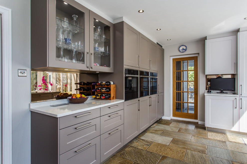 Moderne Wohnküche mit Schrankfronten im Shaker-Stil, grauen Schränken, Quarzit-Arbeitsplatte, Küchenrückwand in Metallic, Kalk-Rückwand, Travertin und gelber Arbeitsplatte in Sussex
