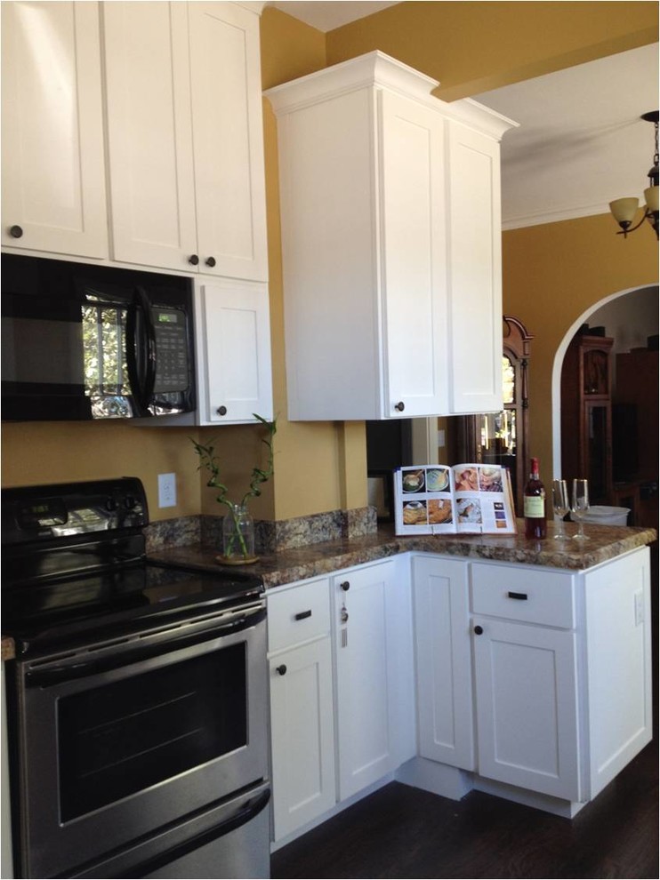 Foto di una cucina stile americano di medie dimensioni con lavello da incasso, ante in stile shaker, ante bianche, top in laminato, elettrodomestici in acciaio inossidabile e parquet scuro