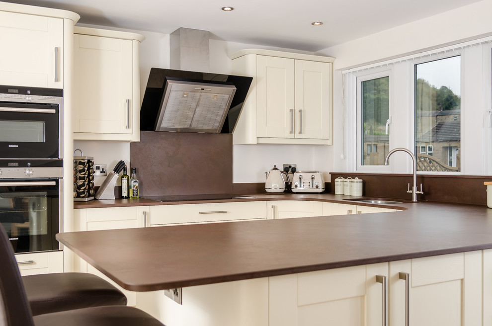 Design ideas for a medium sized contemporary u-shaped kitchen in Other with a submerged sink, composite countertops, brown splashback and stainless steel appliances.