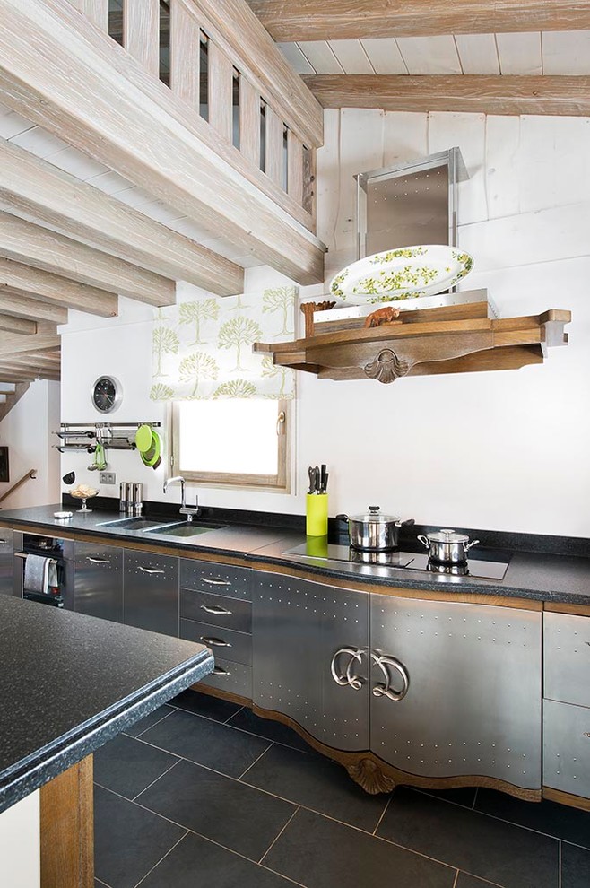 Foto på ett eklektiskt kök, med en dubbel diskho, släta luckor, skåp i rostfritt stål, en köksö, vitt stänkskydd och svarta vitvaror