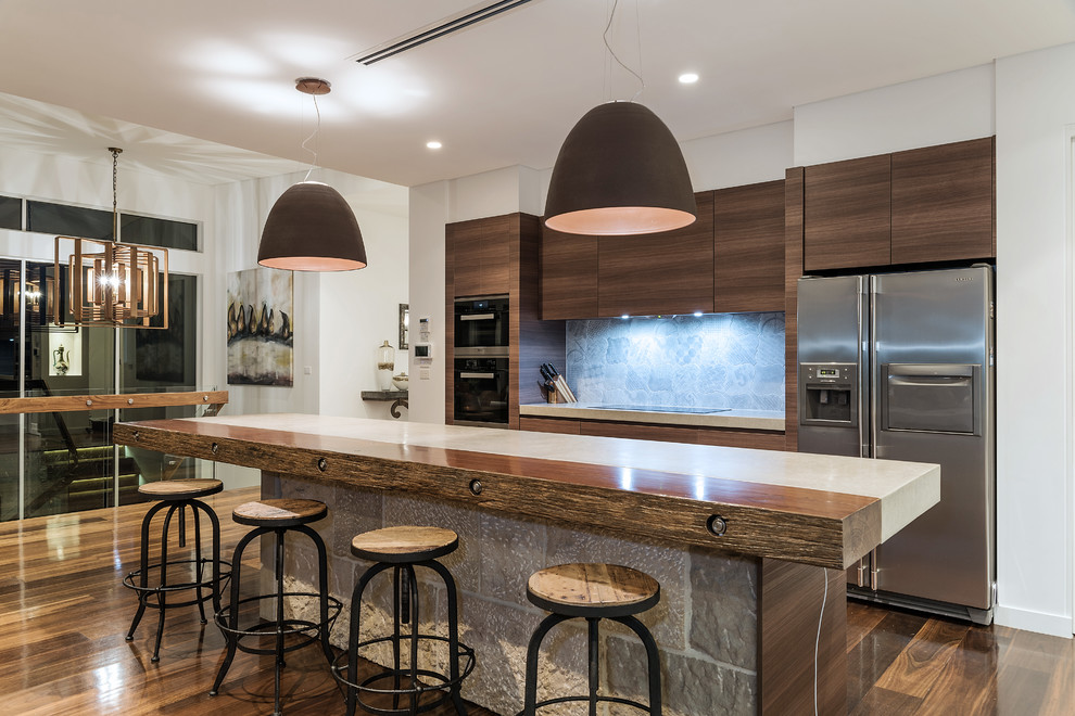 Immagine di una cucina contemporanea con ante lisce, ante in legno bruno, paraspruzzi blu, elettrodomestici in acciaio inossidabile, parquet scuro e pavimento marrone