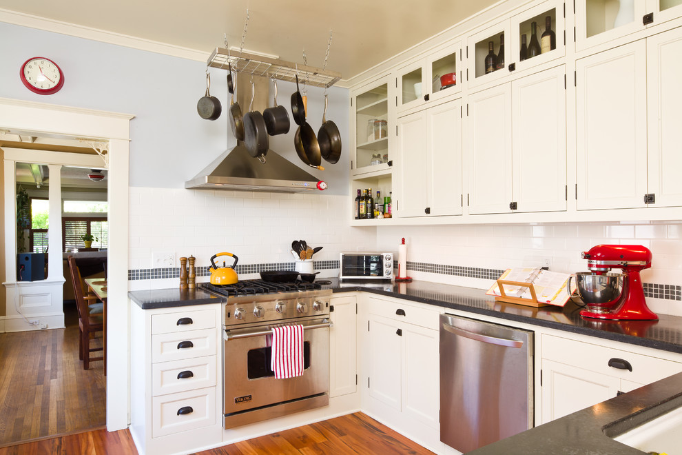 Imagen de cocina tradicional con armarios con paneles empotrados, salpicadero de azulejos tipo metro, puertas de armario blancas, salpicadero blanco y electrodomésticos de acero inoxidable