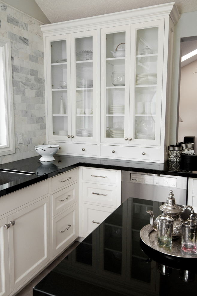 Foto på ett vintage kök, med en undermonterad diskho, luckor med glaspanel, vita skåp, vitt stänkskydd, stänkskydd i tunnelbanekakel, rostfria vitvaror och granitbänkskiva