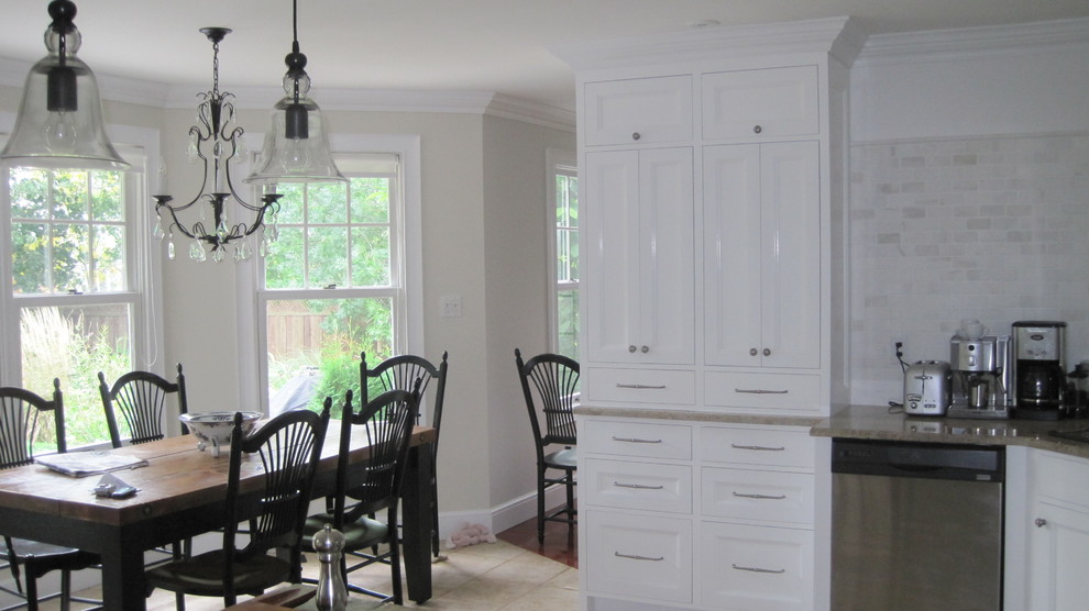 Ejemplo de cocina clásica con armarios con paneles empotrados, puertas de armario blancas, salpicadero blanco, salpicadero de azulejos tipo metro y electrodomésticos de acero inoxidable