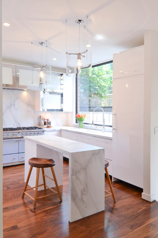 Inredning av ett modernt l-kök, med släta luckor, vita skåp, marmorbänkskiva, vitt stänkskydd, integrerade vitvaror och stänkskydd i marmor