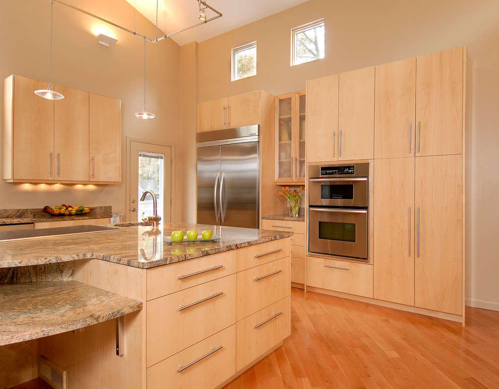 Imagen de cocina contemporánea con fregadero bajoencimera, encimera de granito, salpicadero blanco, electrodomésticos de acero inoxidable, suelo de madera en tonos medios y una isla