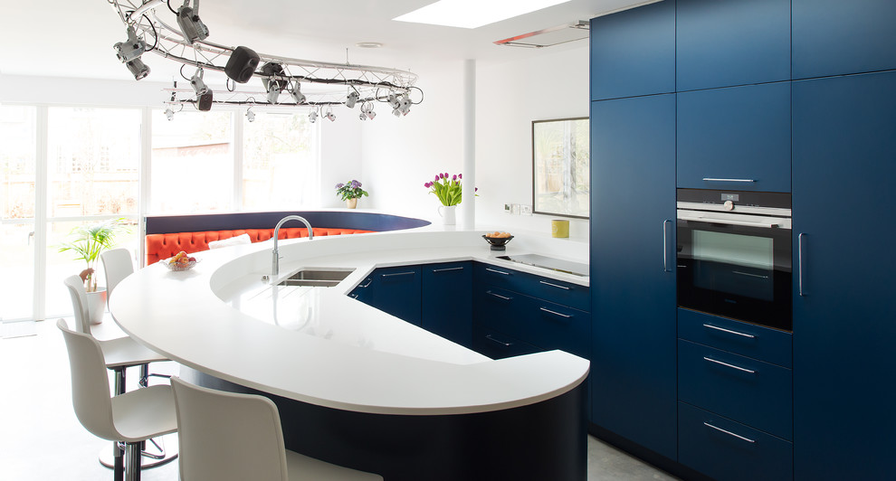 Exempel på ett mellanstort eklektiskt kök, med en dubbel diskho, släta luckor, blå skåp, bänkskiva i koppar, integrerade vitvaror, betonggolv och en halv köksö