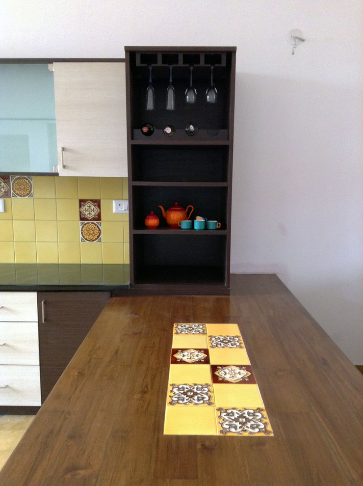 Imagen de cocina asiática con armarios con paneles lisos, puertas de armario de madera en tonos medios, encimera de granito, salpicadero amarillo y una isla