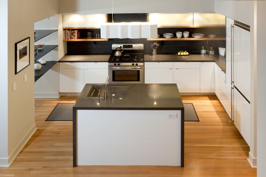 Idee per una grande cucina moderna con lavello sottopiano, ante lisce, ante bianche, paraspruzzi nero, elettrodomestici in acciaio inossidabile e parquet chiaro