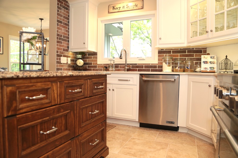 Mid-sized elegant l-shaped ceramic tile and beige floor eat-in kitchen photo in Kansas City with shaker cabinets, white cabinets, granite countertops, multicolored backsplash, stone tile backsplash, stainless steel appliances, an island and an undermount sink