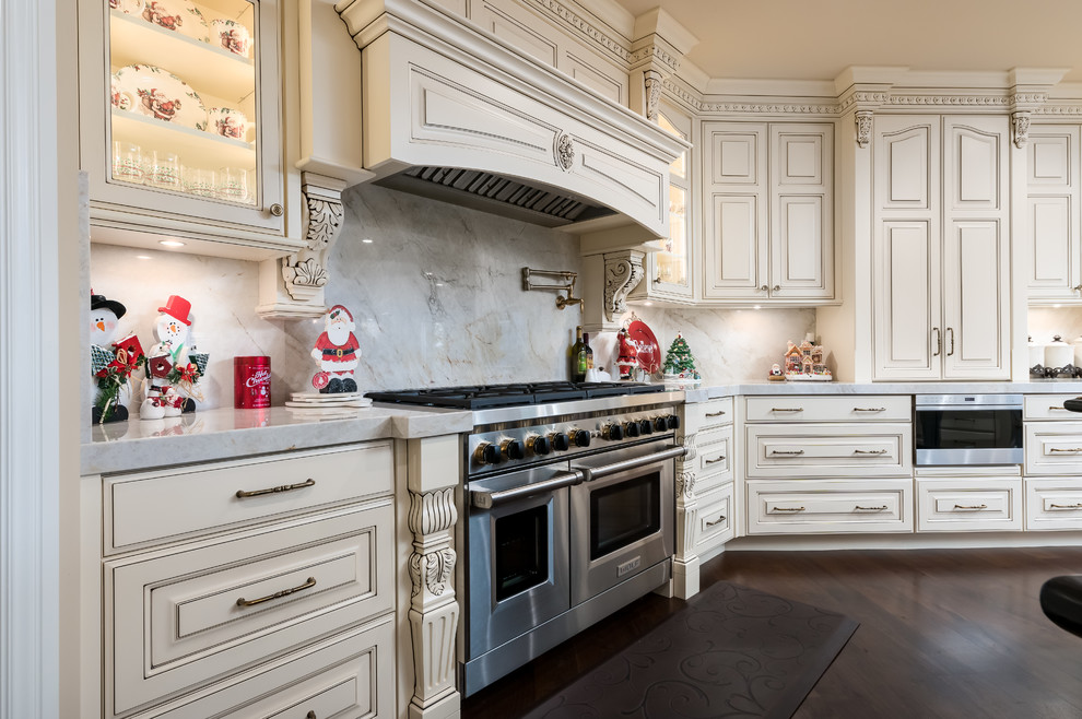 Foto på ett stort vintage vit kök, med en undermonterad diskho, luckor med upphöjd panel, vita skåp, bänkskiva i kvarts, vitt stänkskydd, stänkskydd i sten, mellanmörkt trägolv, flera köksöar, brunt golv och rostfria vitvaror