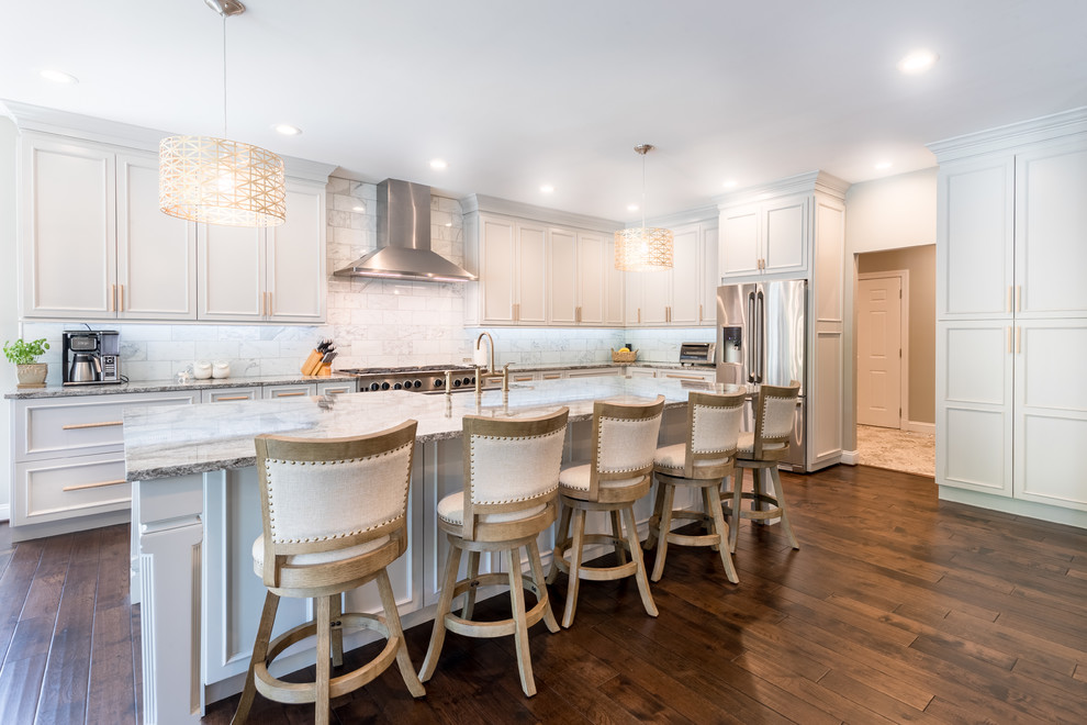 Example of a mid-sized classic l-shaped dark wood floor and brown floor eat-in kitchen design in DC Metro with a farmhouse sink, beaded inset cabinets, white cabinets, granite countertops, white backsplash, marble backsplash, stainless steel appliances and an island