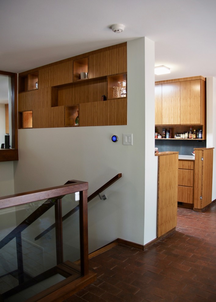 ローリーにある小さなコンテンポラリースタイルのおしゃれなキッチン (アンダーカウンターシンク、フラットパネル扉のキャビネット、中間色木目調キャビネット、クオーツストーンカウンター、グレーのキッチンパネル、セラミックタイルのキッチンパネル、シルバーの調理設備、レンガの床、アイランドなし、赤い床、白いキッチンカウンター) の写真