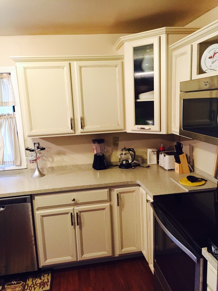 Modern inredning av ett avskilt, litet l-kök, med en undermonterad diskho, luckor med infälld panel, vita skåp, bänkskiva i koppar, rostfria vitvaror, mörkt trägolv och en köksö