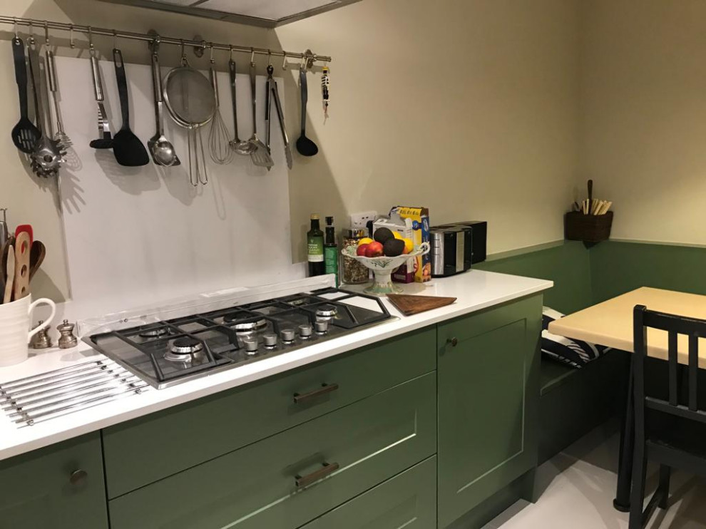 На фото: кухня среднего размера в стиле модернизм с зелеными фасадами, белым фартуком, белым полом и белой столешницей с