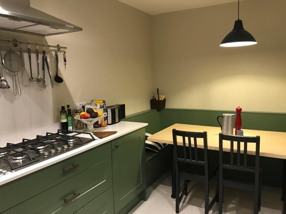 На фото: кухня среднего размера в стиле модернизм с зелеными фасадами, белым фартуком, белым полом и белой столешницей