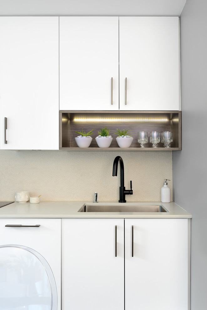 Example of a small minimalist galley black floor eat-in kitchen design in Toronto with an undermount sink, flat-panel cabinets, white cabinets, stainless steel appliances and no island