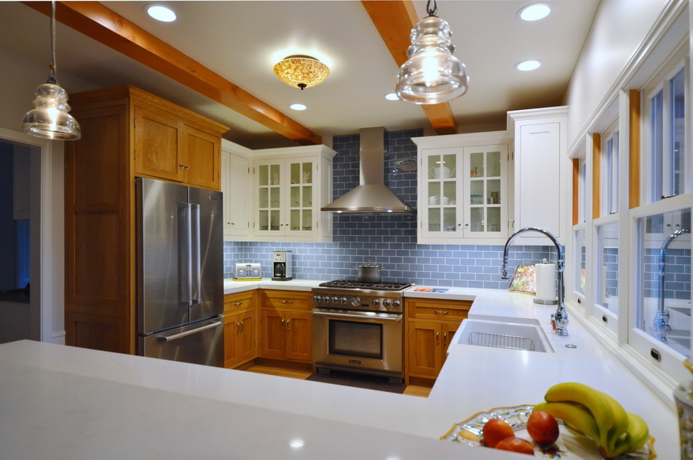 Example of a mid-sized country u-shaped light wood floor kitchen design in Los Angeles with a farmhouse sink, shaker cabinets, medium tone wood cabinets, quartzite countertops, blue backsplash, glass tile backsplash, stainless steel appliances and a peninsula