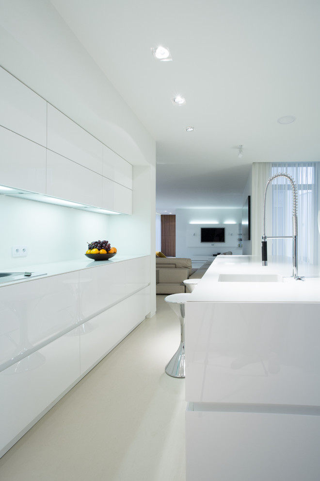 Foto de cocina comedor moderna con puertas de armario blancas, salpicadero blanco, una isla y encimeras blancas