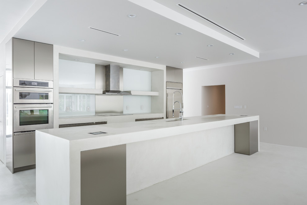 Open concept kitchen - mid-sized contemporary galley concrete floor open concept kitchen idea in Miami with an undermount sink, flat-panel cabinets, stainless steel cabinets, concrete countertops, blue backsplash, glass sheet backsplash, stainless steel appliances and an island