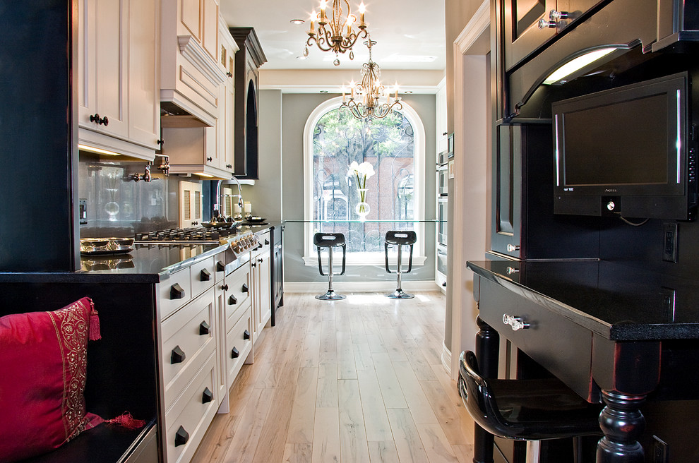 デトロイトにある高級な中くらいなヴィクトリアン調のおしゃれなキッチン (シェーカースタイル扉のキャビネット、白いキャビネット、パネルと同色の調理設備、淡色無垢フローリング) の写真