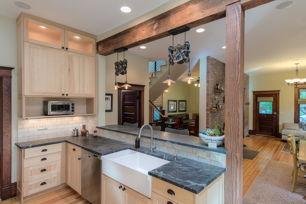 Immagine di una cucina design con lavello stile country, ante in legno chiaro e elettrodomestici in acciaio inossidabile