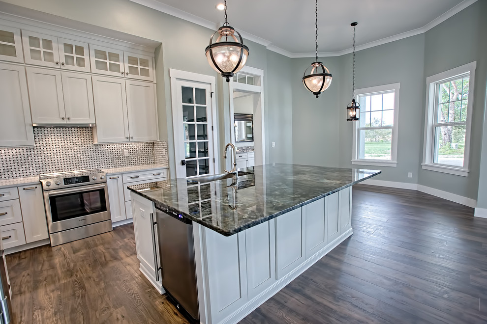 Foto di una cucina design con lavello sottopiano, ante con riquadro incassato, ante bianche, top in granito e elettrodomestici in acciaio inossidabile