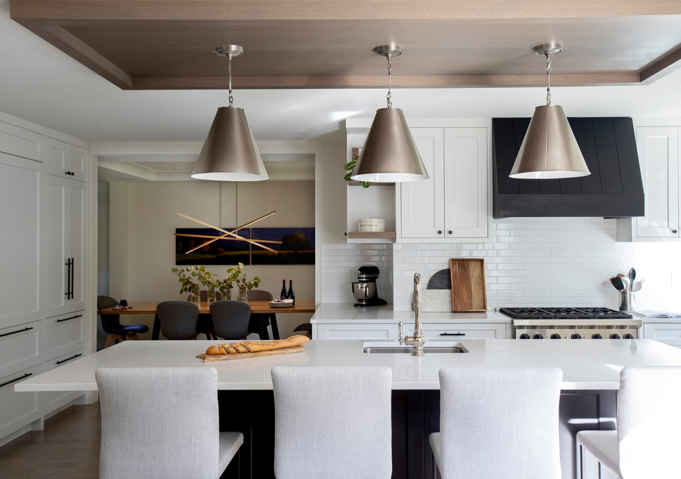 Foto di una cucina moderna con ante in stile shaker, paraspruzzi bianco, elettrodomestici da incasso, pavimento in legno massello medio e top bianco