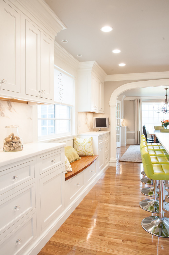 Transitional eat-in kitchen photo in Manchester with white cabinets, beaded inset cabinets, marble countertops, white backsplash, marble backsplash and an island