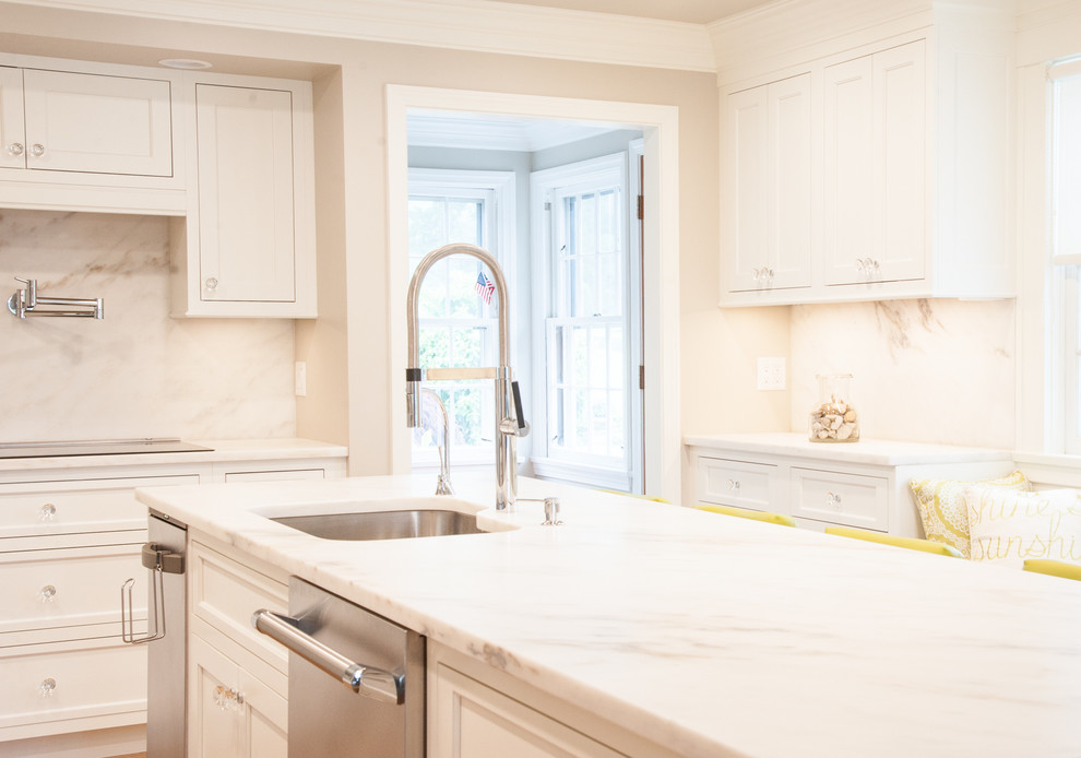 Exempel på ett klassiskt kök och matrum, med en undermonterad diskho, luckor med profilerade fronter, vita skåp, marmorbänkskiva, vitt stänkskydd, stänkskydd i marmor, rostfria vitvaror och en köksö