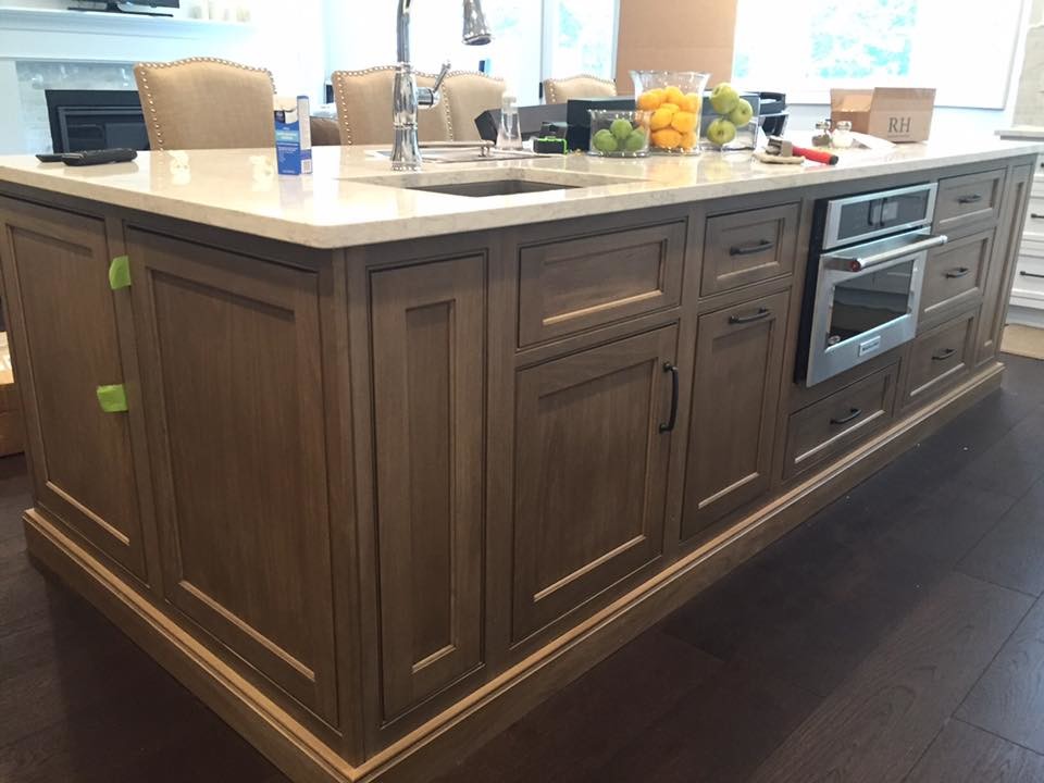 Exempel på ett mellanstort modernt linjärt kök och matrum, med en undermonterad diskho, luckor med infälld panel, marmorbänkskiva, grått stänkskydd, stänkskydd i glaskakel, rostfria vitvaror, mörkt trägolv, en köksö och bruna skåp