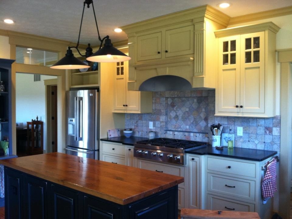 Example of a large country light wood floor kitchen design in Other with a farmhouse sink, soapstone countertops, stainless steel appliances, an island and recessed-panel cabinets