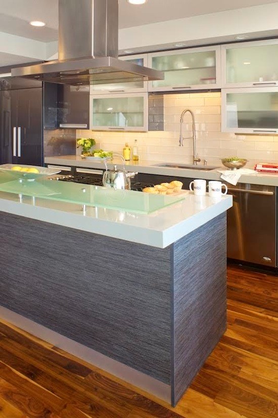 Inspiration for a contemporary galley dark wood floor open concept kitchen remodel in Denver with a drop-in sink, glass-front cabinets, brown cabinets, quartz countertops, yellow backsplash, glass tile backsplash, stainless steel appliances and an island