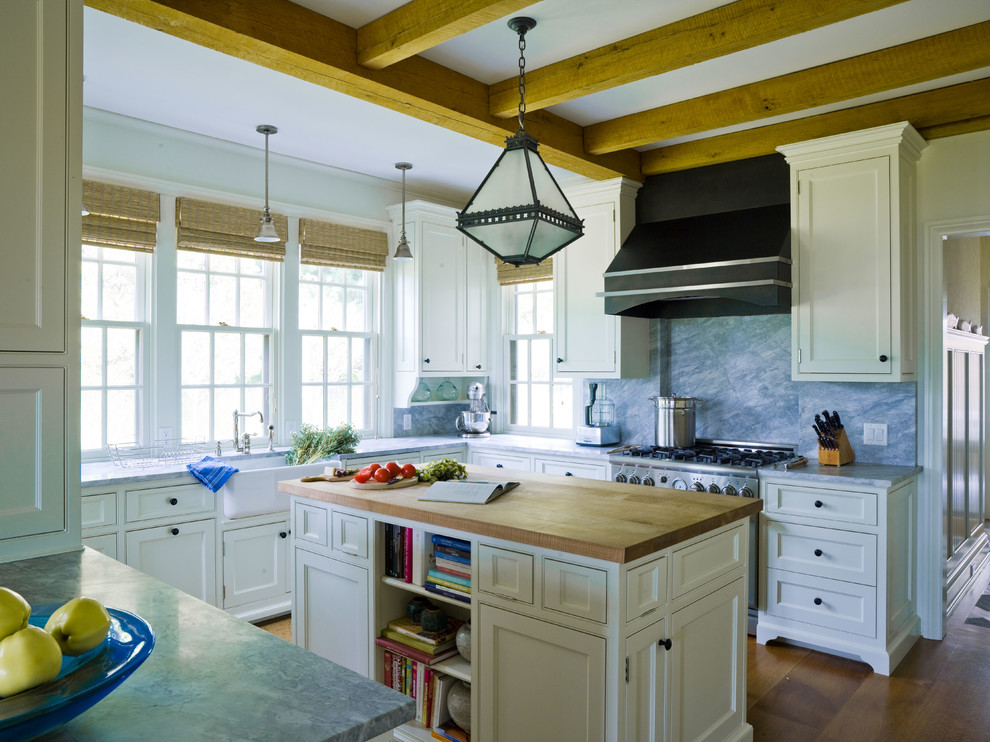 Foto di una cucina ad U costiera con ante a filo, ante bianche, paraspruzzi blu e paraspruzzi in lastra di pietra