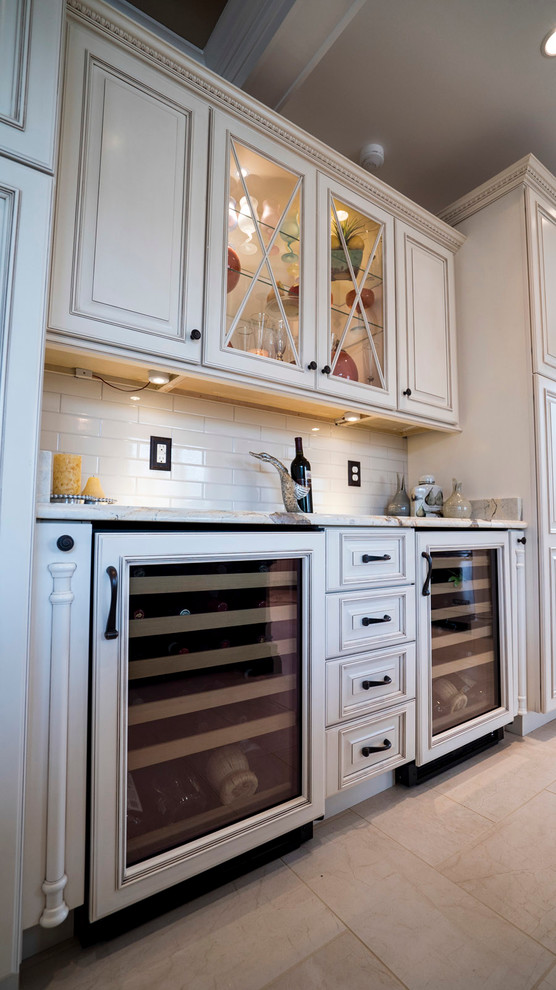 Inspiration for a large timeless u-shaped eat-in kitchen remodel in DC Metro with a farmhouse sink, raised-panel cabinets, white cabinets, granite countertops, white backsplash, paneled appliances and an island
