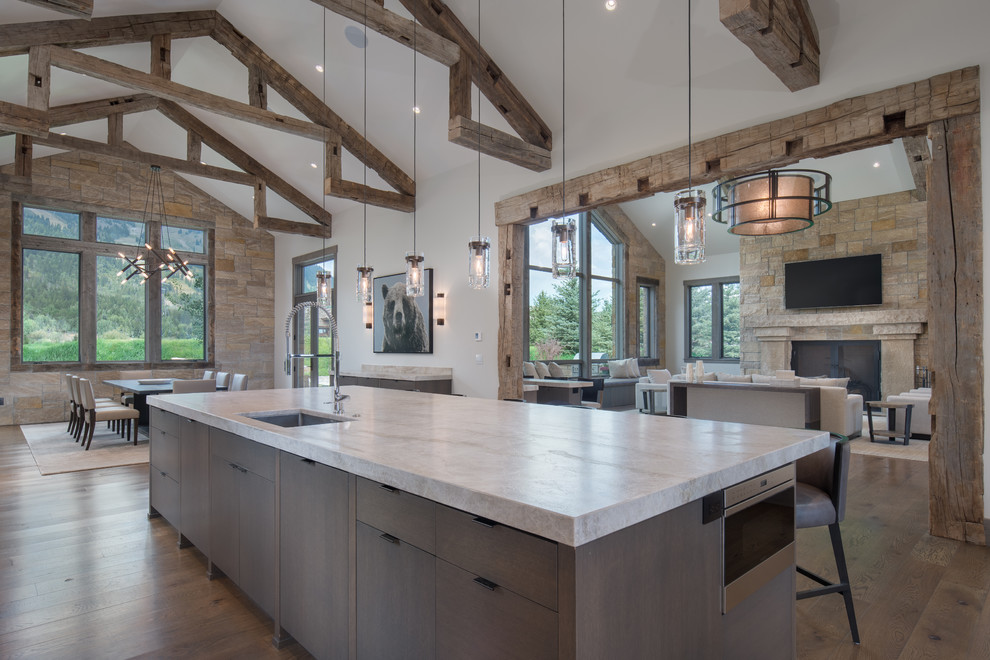 This is an example of a rustic kitchen/diner in Other with flat-panel cabinets, quartz worktops, stone slab splashback, stainless steel appliances and an island.