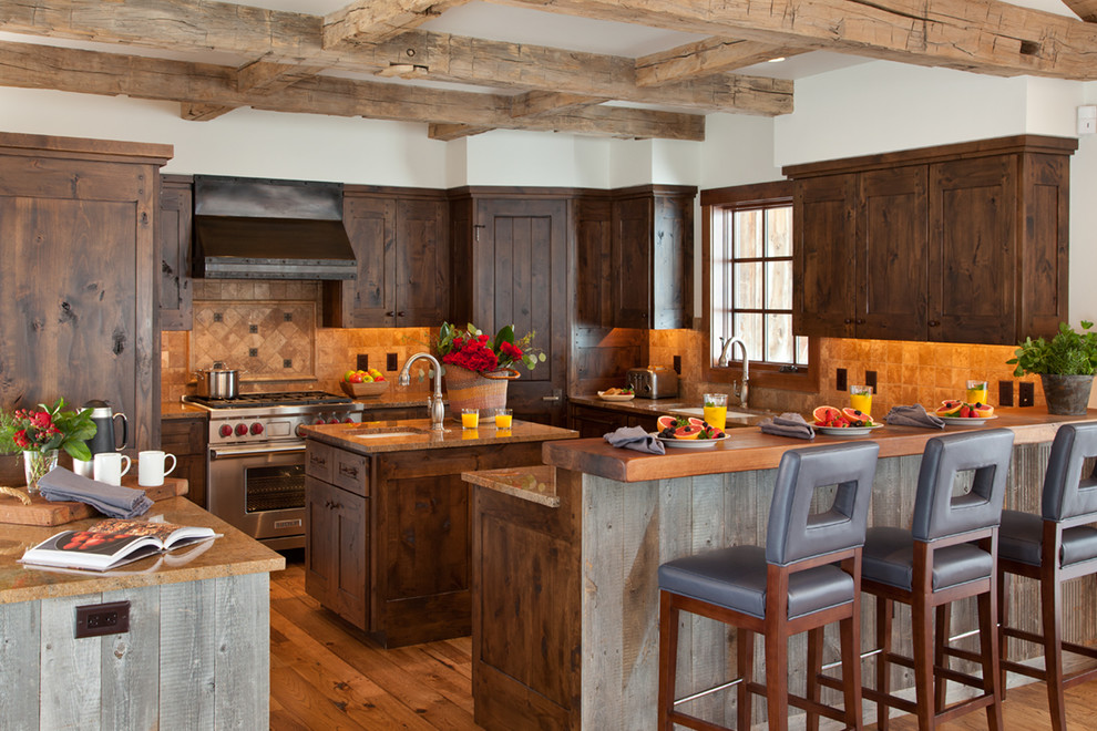 Foto på ett stort rustikt u-kök, med en undermonterad diskho, skåp i shakerstil, skåp i mörkt trä, beige stänkskydd, stänkskydd i stenkakel, rostfria vitvaror, mellanmörkt trägolv, en köksö och brunt golv