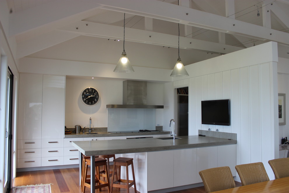 Mid-sized trendy galley kitchen pantry photo in Melbourne with flat-panel cabinets, white cabinets and an island