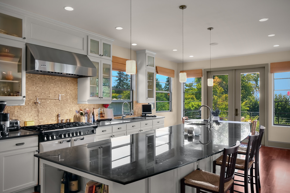 Design ideas for a classic kitchen in Seattle with glass-front cabinets, mosaic tiled splashback, white appliances, brown splashback, white cabinets and a submerged sink.