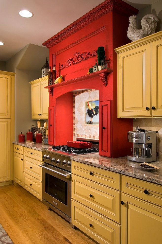 Landhaus Küche mit profilierten Schrankfronten, gelben Schränken und Granit-Arbeitsplatte in New York