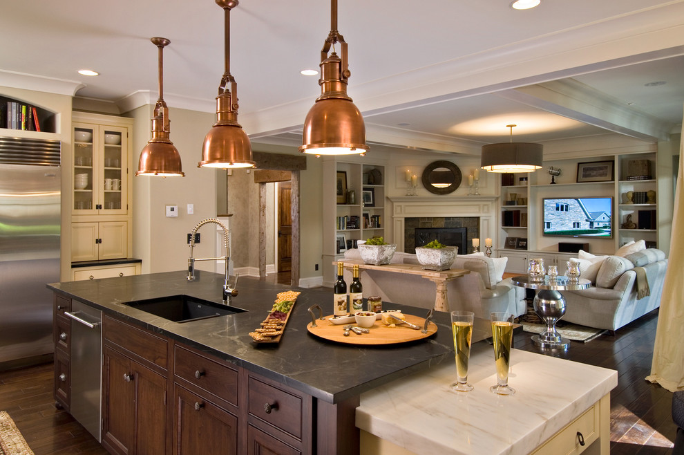 Elegant open concept kitchen photo in New York with stainless steel appliances, soapstone countertops, an undermount sink, beaded inset cabinets and dark wood cabinets