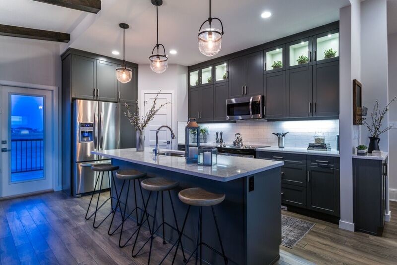 Example of a mid-sized minimalist galley laminate floor eat-in kitchen design in Calgary with an undermount sink, shaker cabinets, gray cabinets, granite countertops, white backsplash, subway tile backsplash, stainless steel appliances and an island