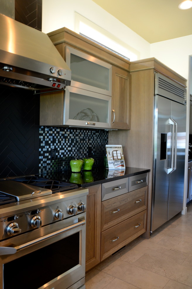 Klassische Wohnküche in L-Form mit flächenbündigen Schrankfronten, Edelstahlfronten, Granit-Arbeitsplatte, Küchenrückwand in Schwarz und Küchengeräten aus Edelstahl in Calgary