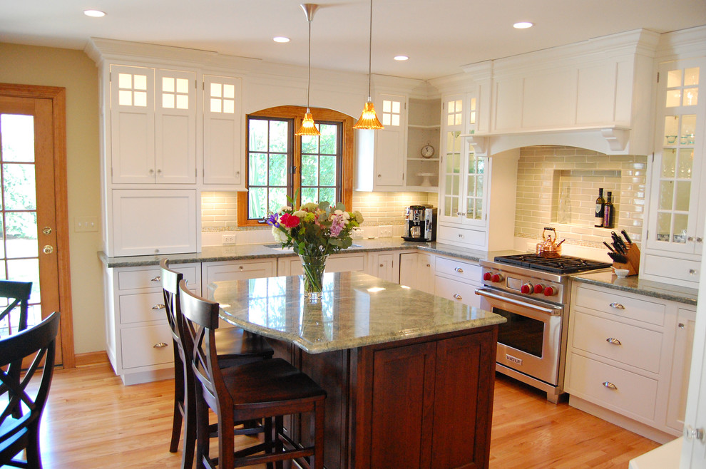 Eat-in kitchen - mid-sized traditional u-shaped light wood floor eat-in kitchen idea in Chicago with flat-panel cabinets, white cabinets, green backsplash, subway tile backsplash, stainless steel appliances, an undermount sink, granite countertops and an island