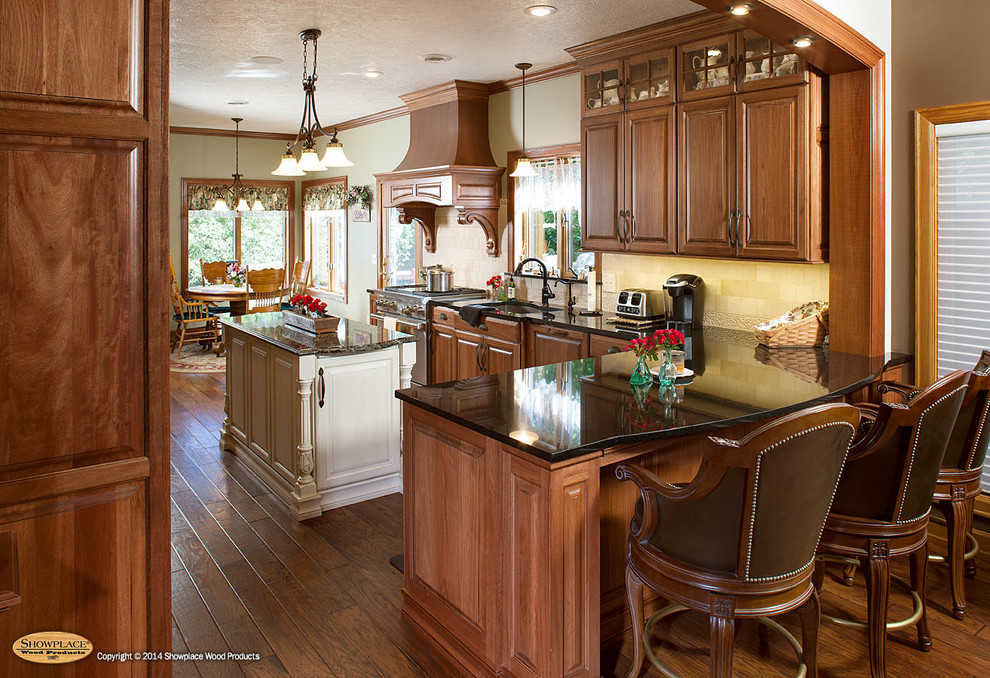 Elegant galley kitchen photo in Other with raised-panel cabinets, granite countertops, stainless steel appliances and an island