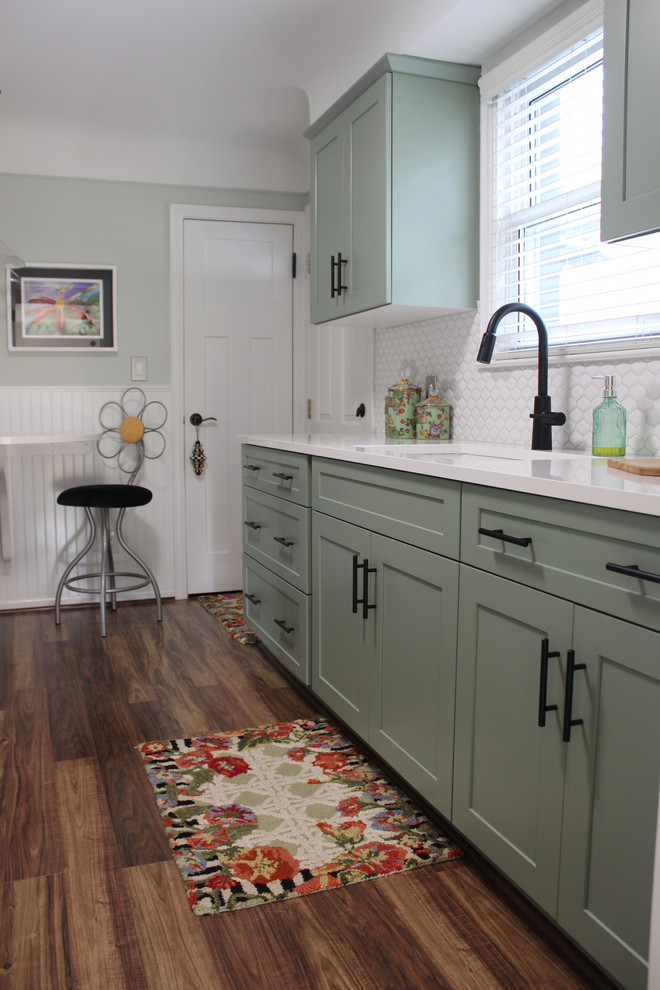 Modelo de cocina minimalista con armarios con paneles empotrados, puertas de armario verdes, encimera de cuarzo compacto y encimeras blancas